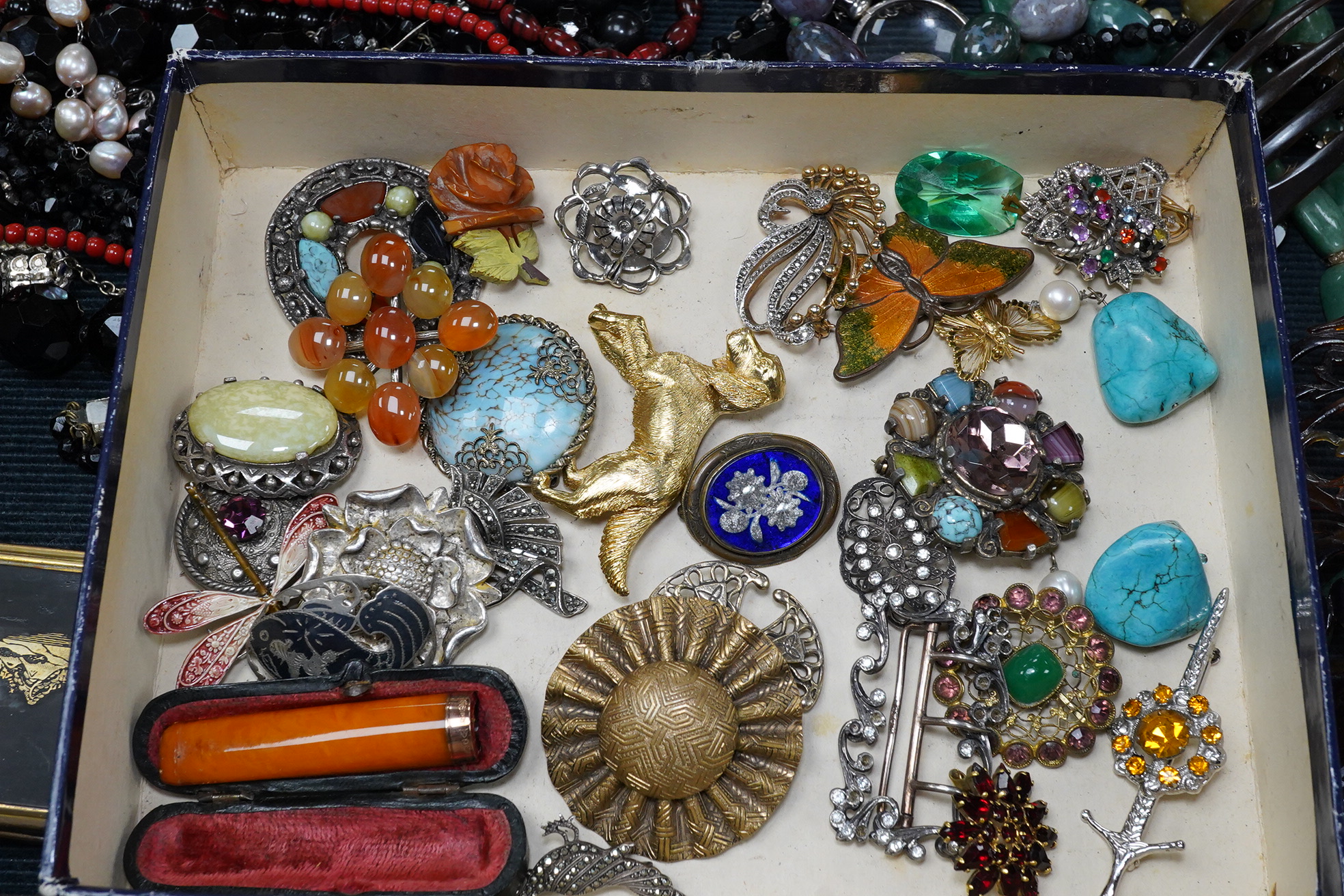 A group of assorted costume jewellery including an amber cigar holder and a Burberry gilt metal spaniel brooch